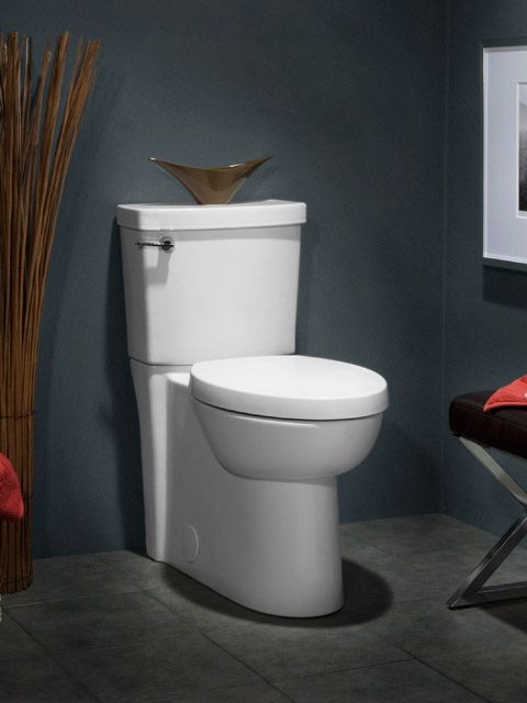 A white toilet in a bathroom with a picture on the wall
