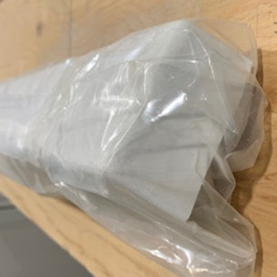 A plastic bag is sitting on a wooden table.