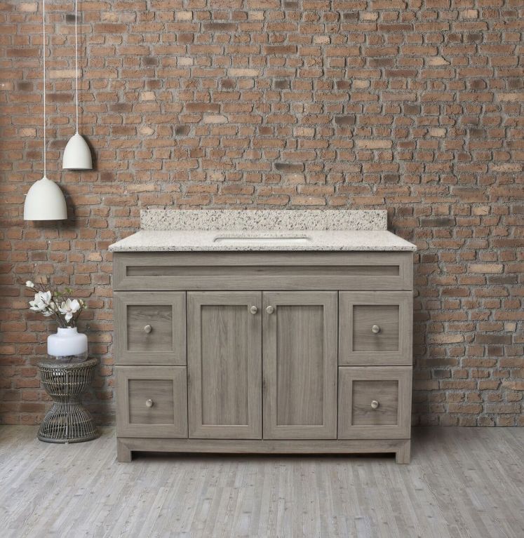 A bathroom vanity with a brick wall behind it