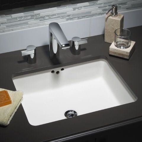 A bathroom sink with a soap dispenser next to it