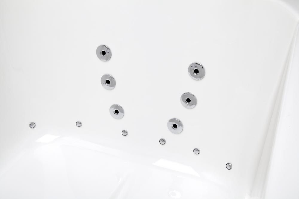 A white bathtub with a lot of jets coming out of it.