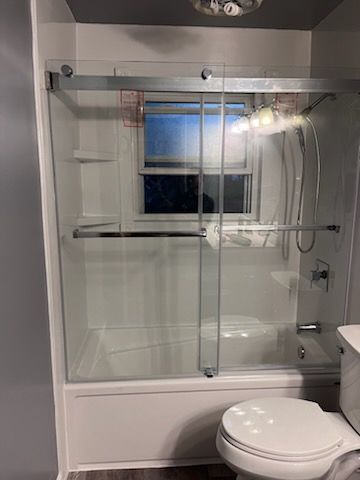 A bathroom with a tub , toilet and shower.