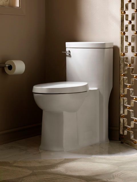 A bathroom with a toilet and a paper towel holder