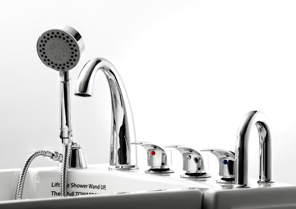 A bathroom sink with a shower head and faucets.