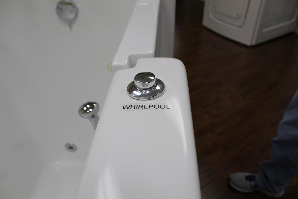 A person is standing next to a whirlpool bathtub