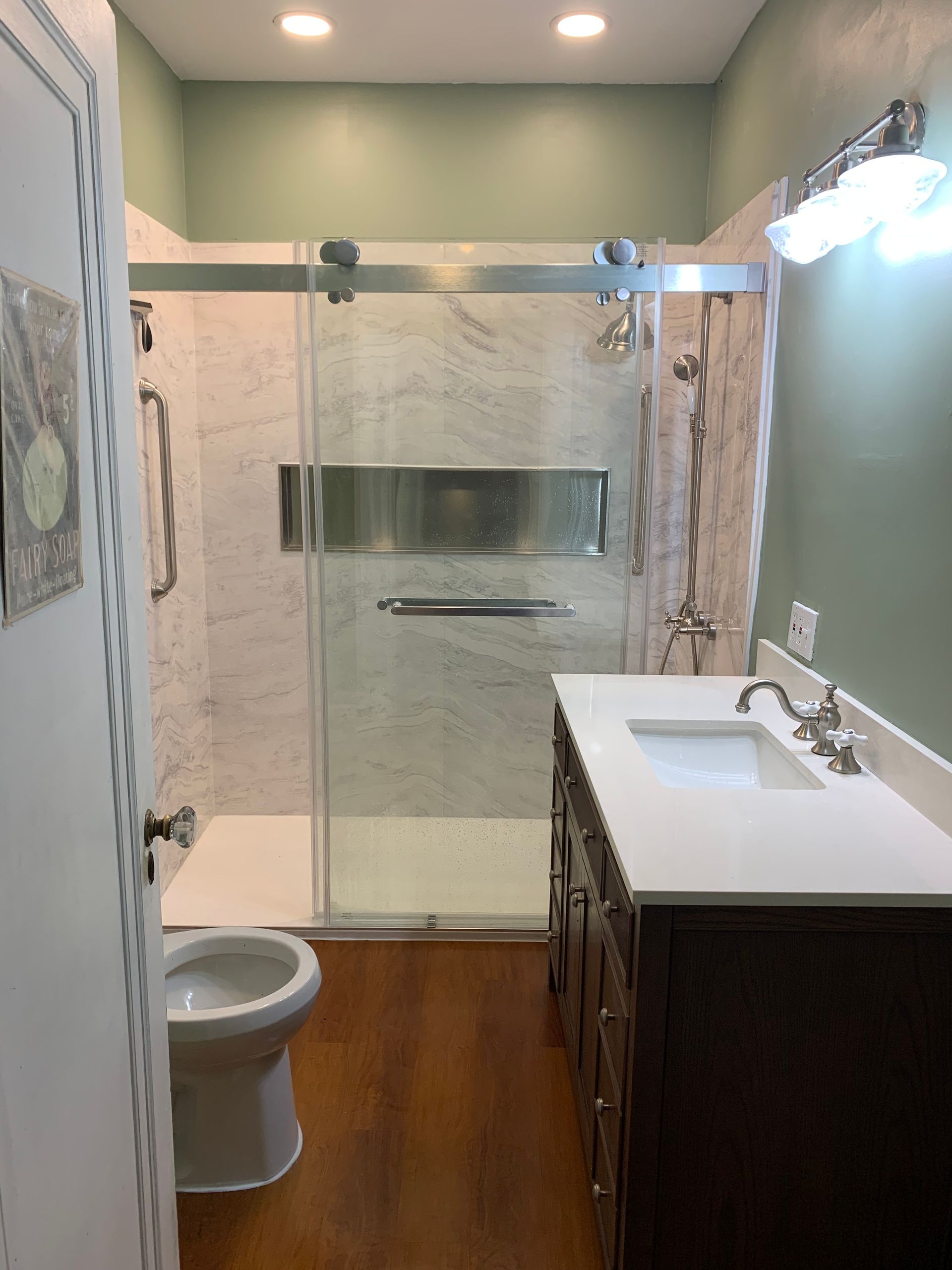 A bathroom with a toilet and a walk in shower.