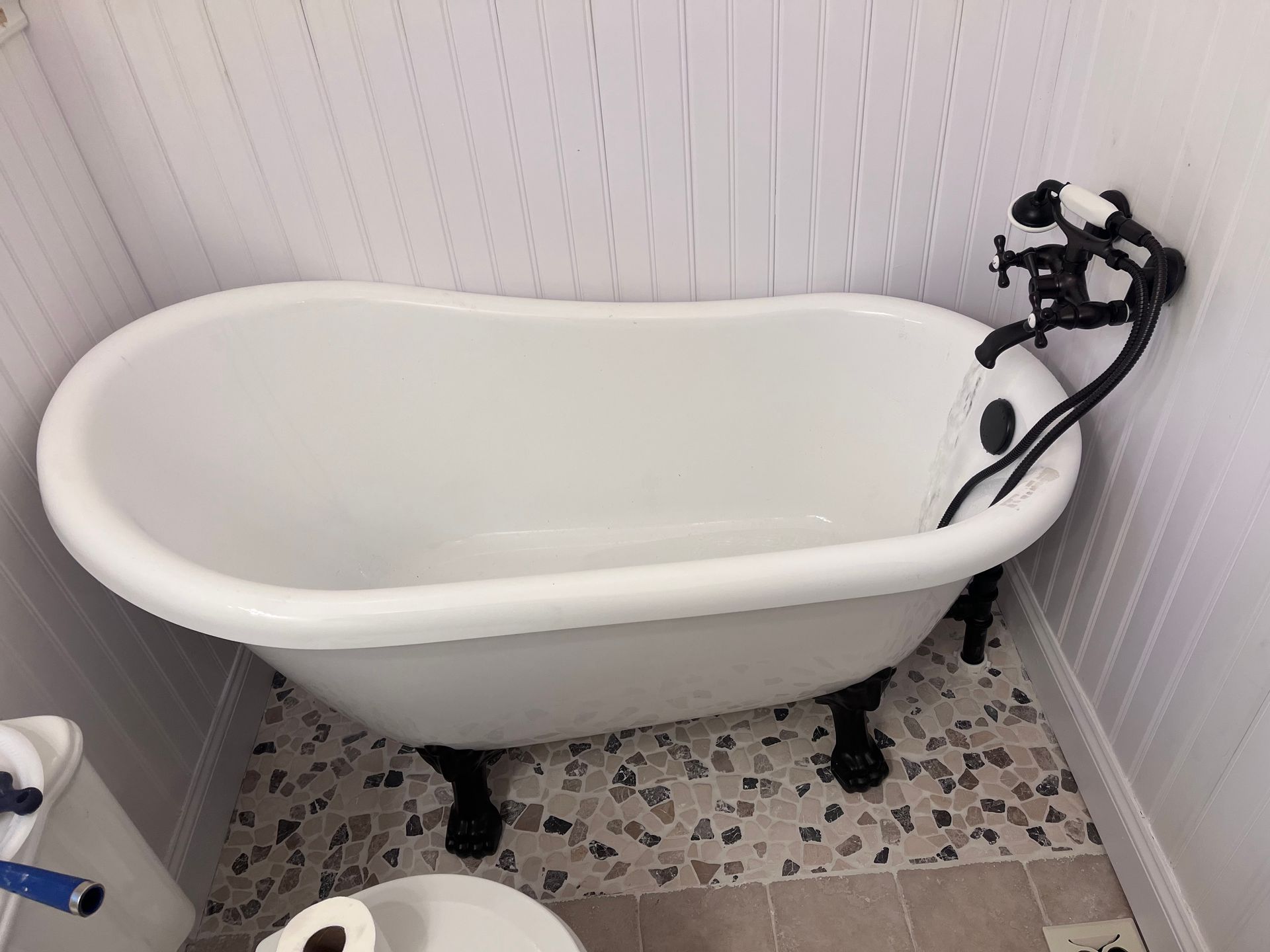 A bathroom with a tub , toilet and shower.