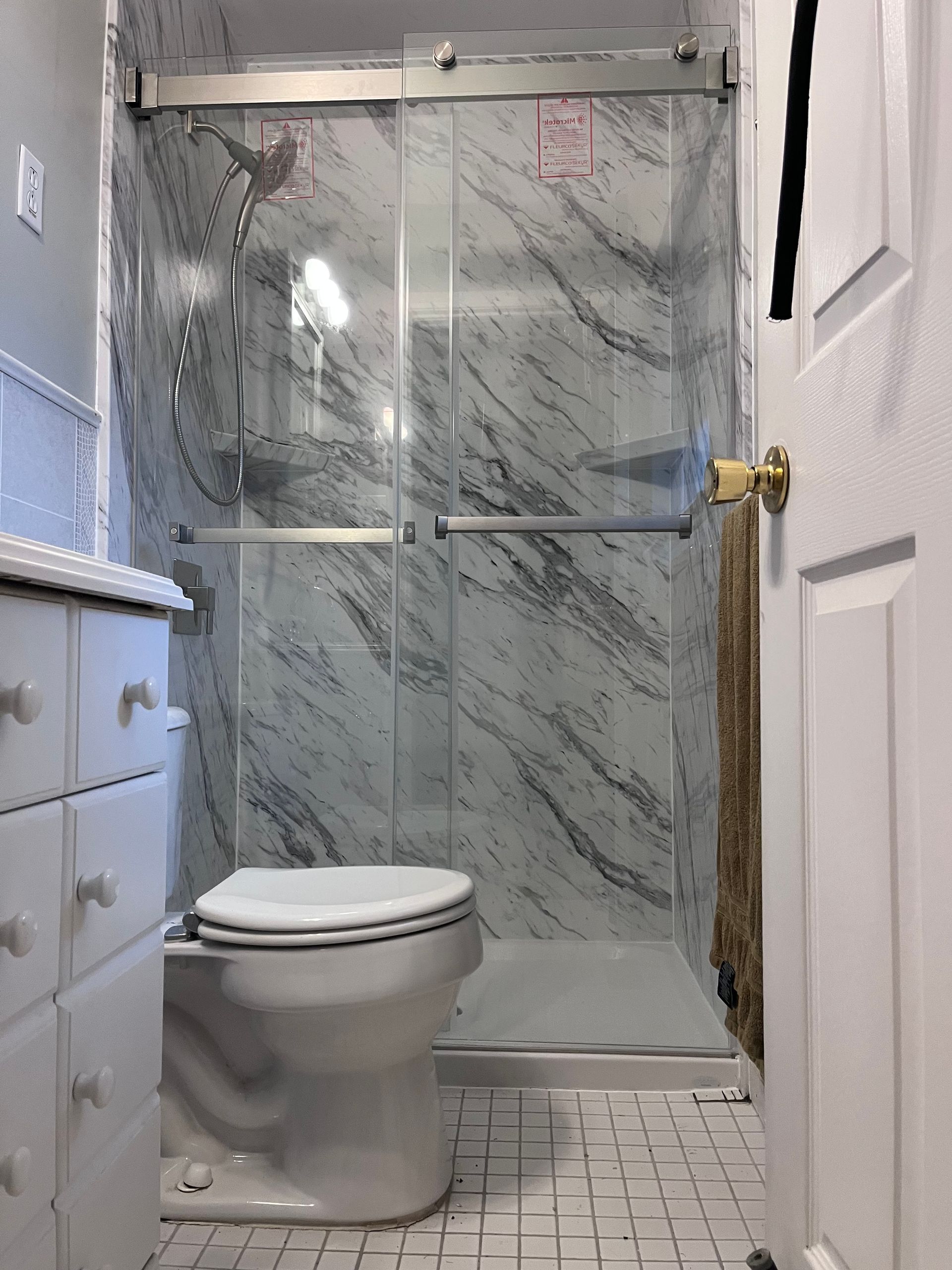 A bathroom with a tub , toilet and shower.