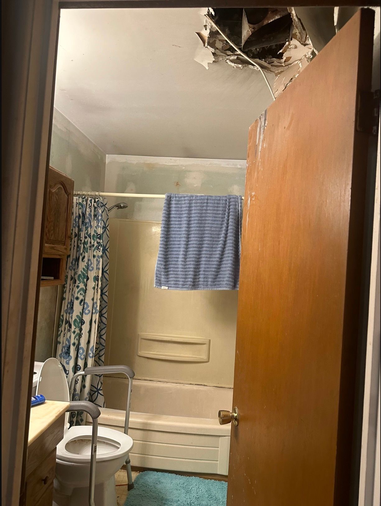 A bathroom with a toilet , tub and mirror.
