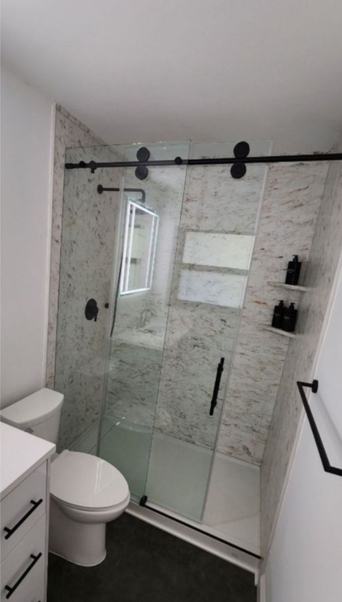A bathroom with a toilet , sink , and walk in shower.