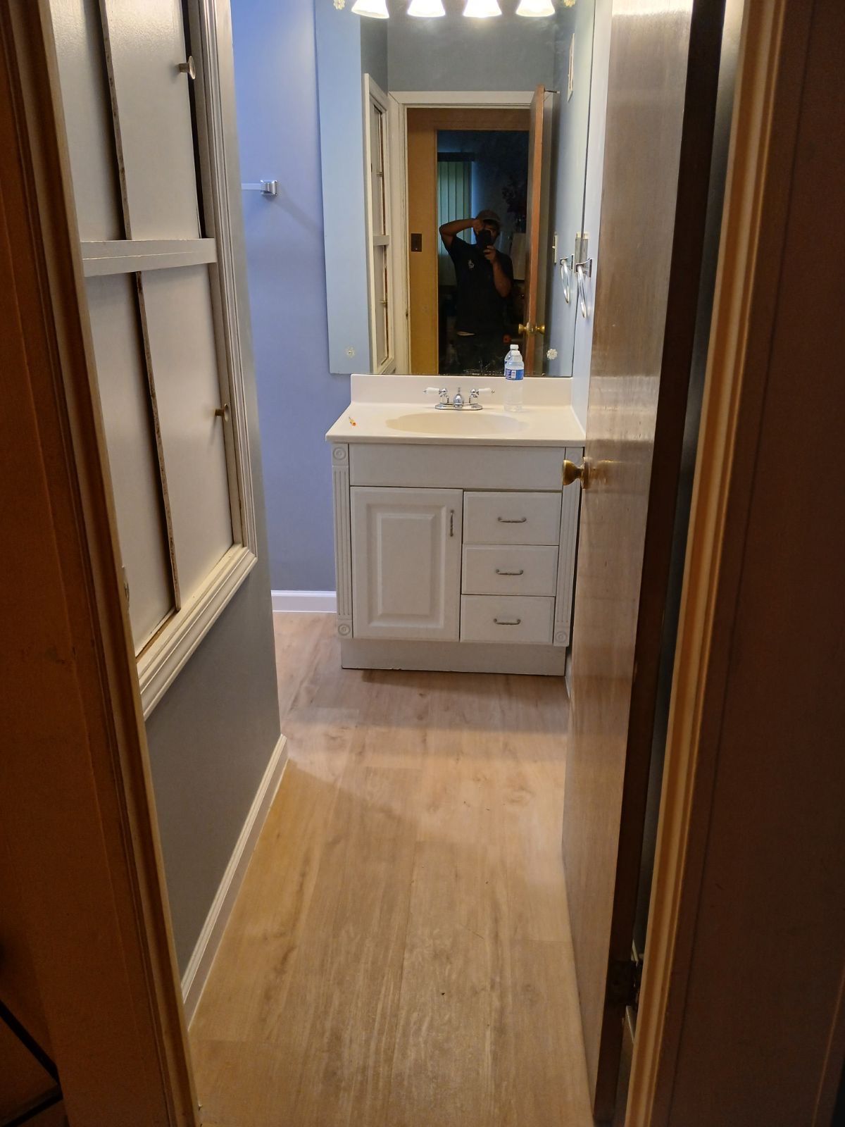 A bathroom with a toilet a sink and a mirror