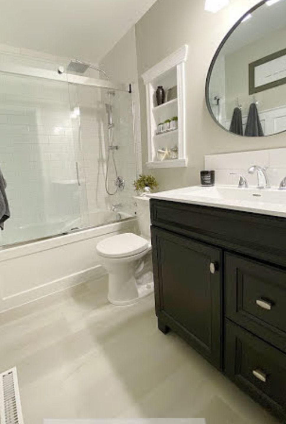 A bathroom with a toilet , sink , bathtub and mirror.