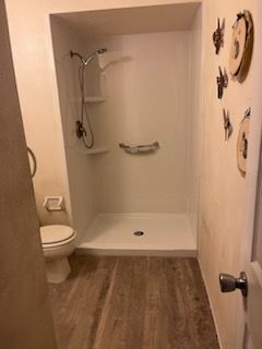 A bathroom with a toilet and a walk in shower.