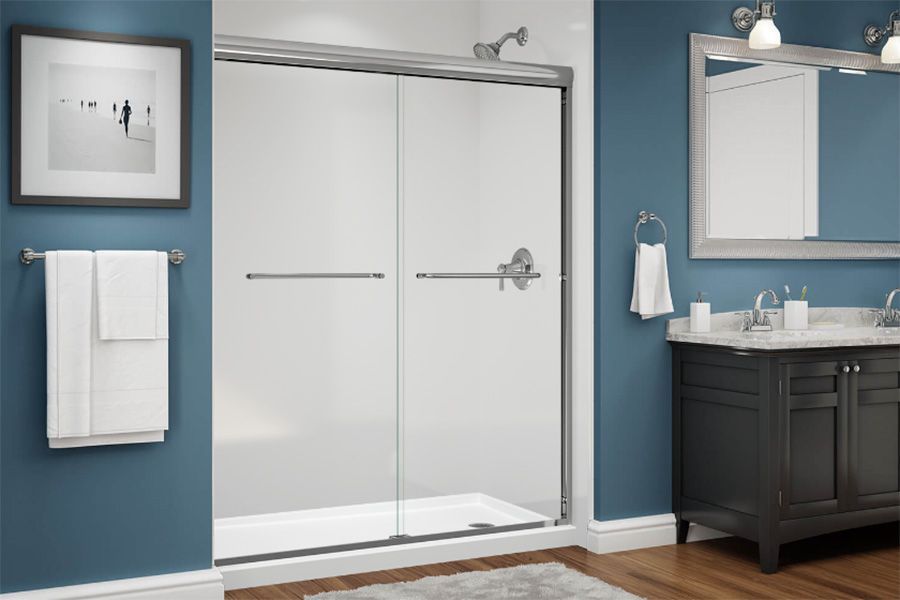 A bathroom with a sliding glass shower door and a sink.