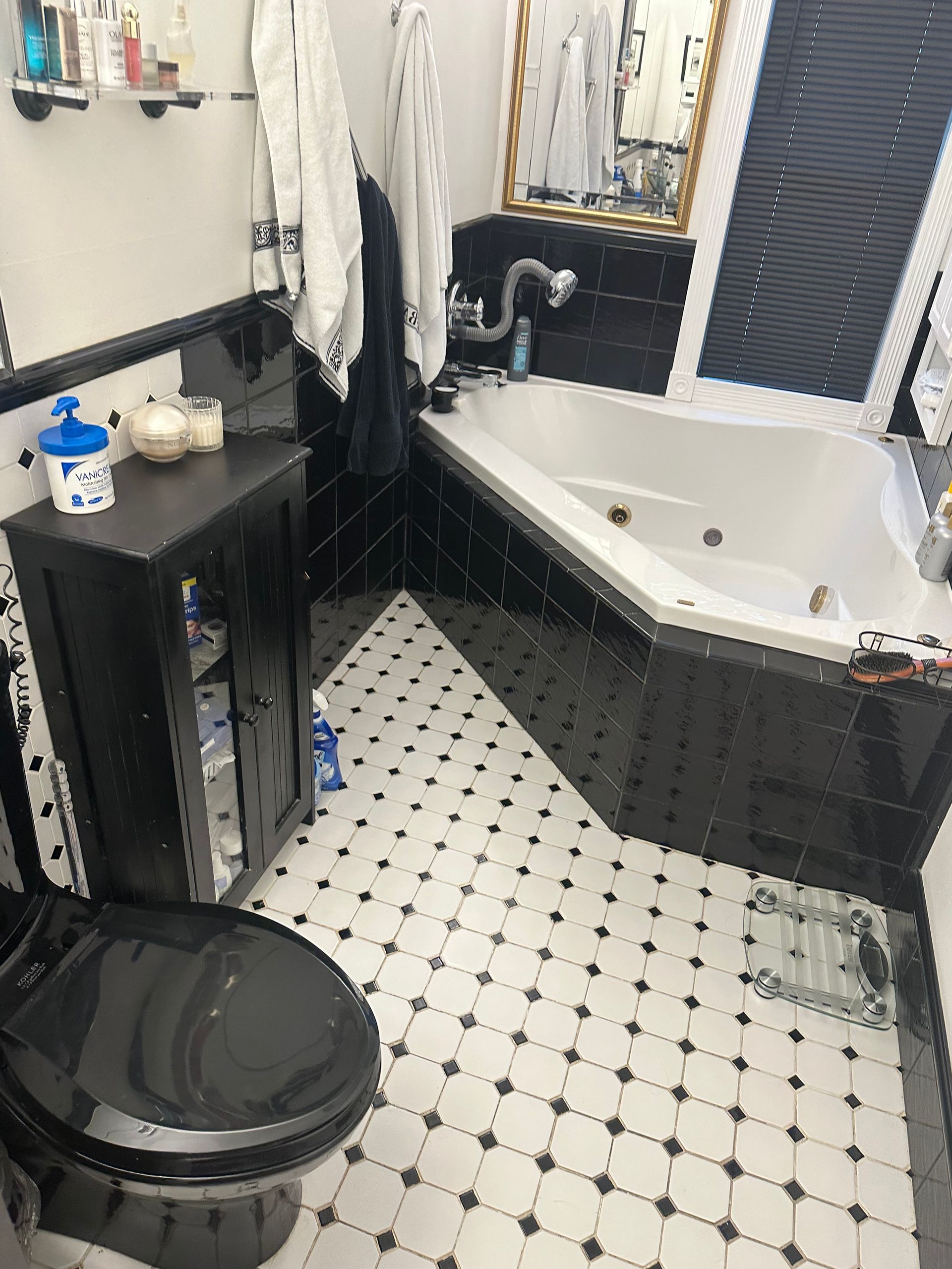 A bathroom with a toilet , tub and mirror.