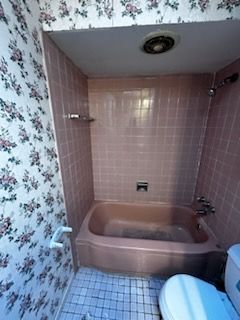 A bathroom with a jacuzzi tub and a toilet