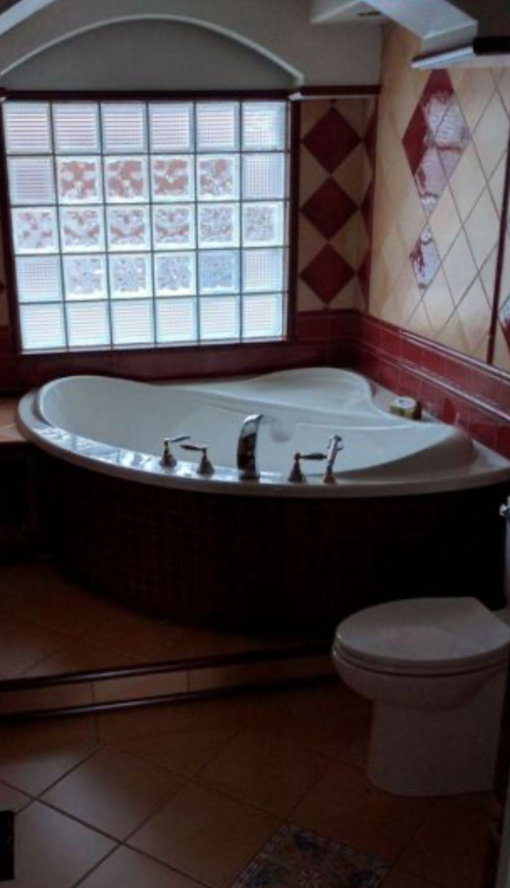 A bathroom with a jacuzzi tub and a toilet