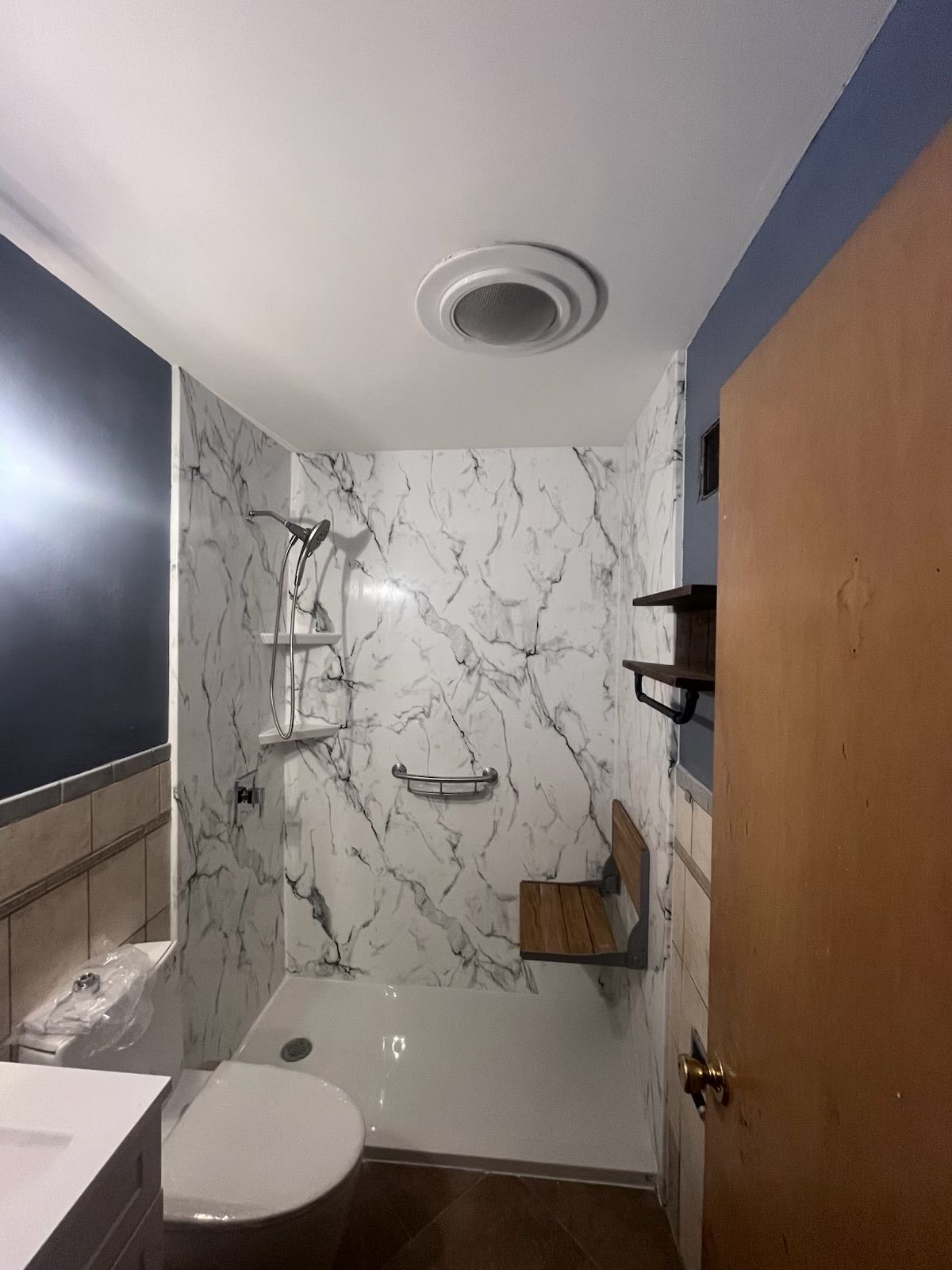 A bathroom with a toilet , sink and shower.