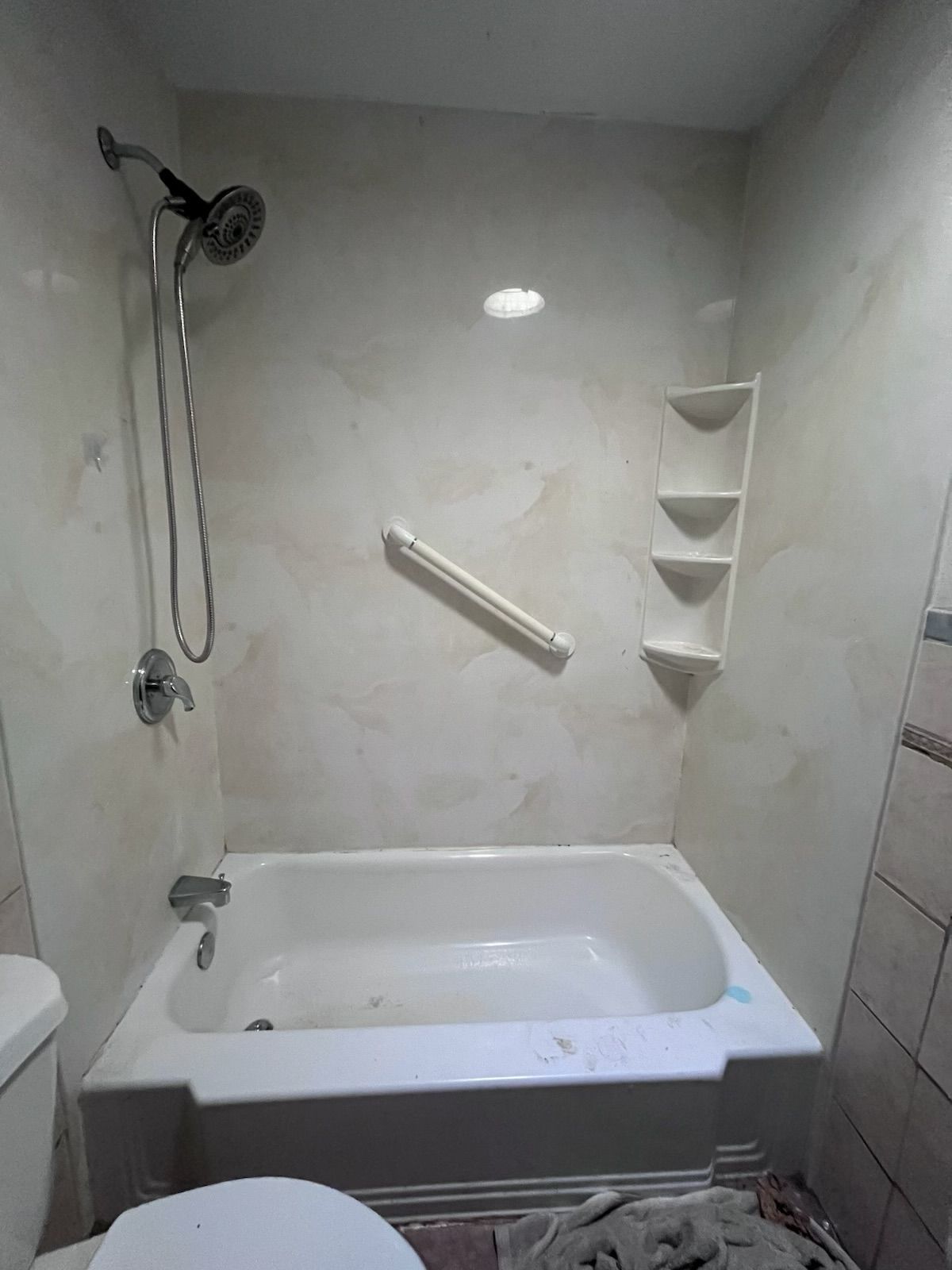A bathroom with a bathtub , toilet and shower.