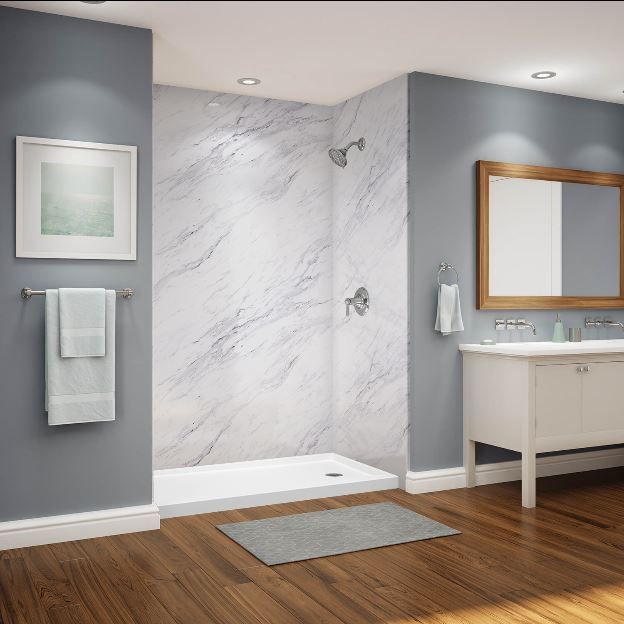 A bathroom with a walk in shower a sink and a mirror