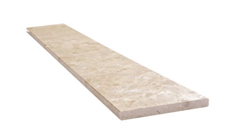 A long piece of marble is sitting on a white surface.