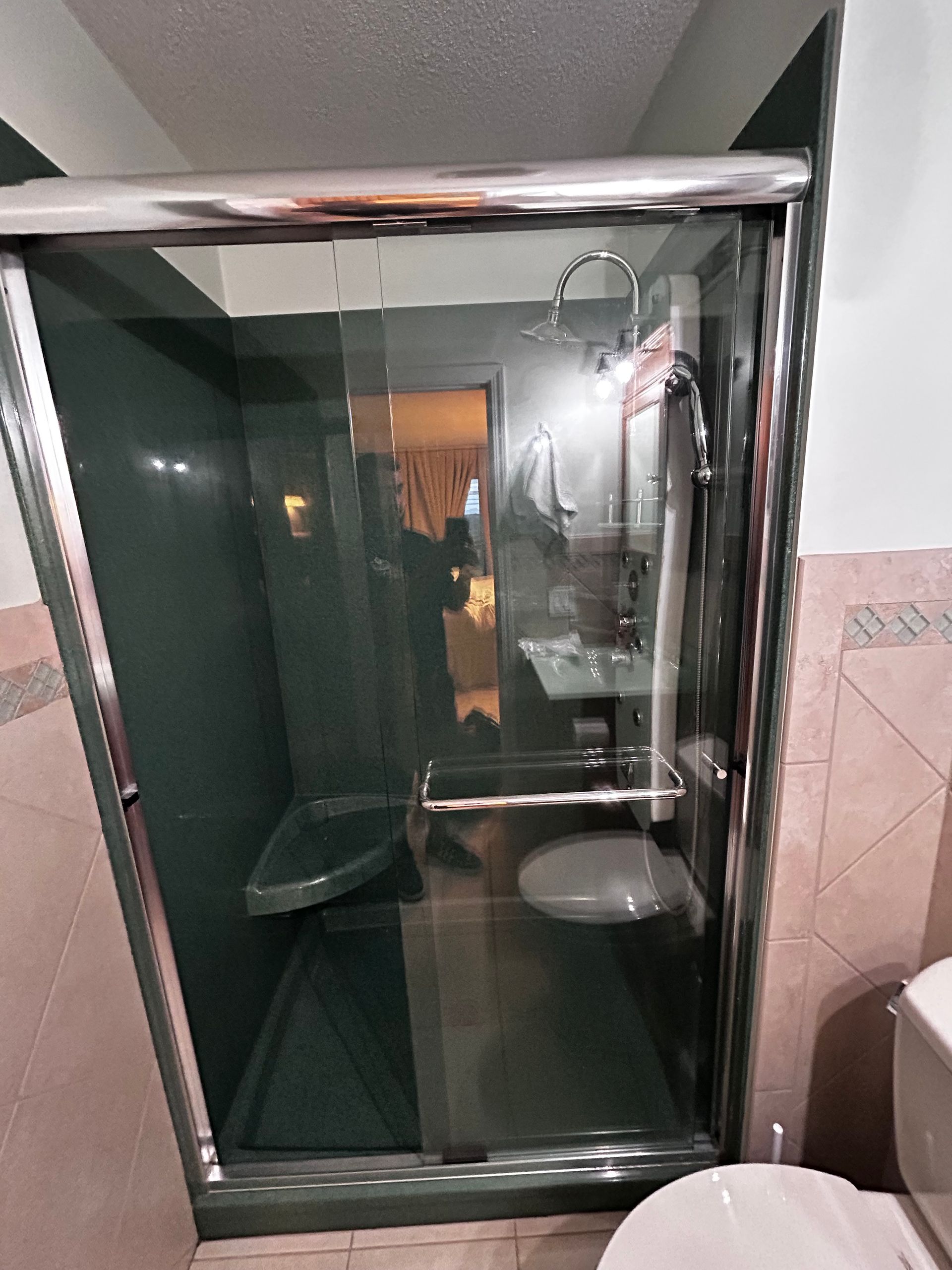 A bathroom with a sliding glass shower door and a toilet