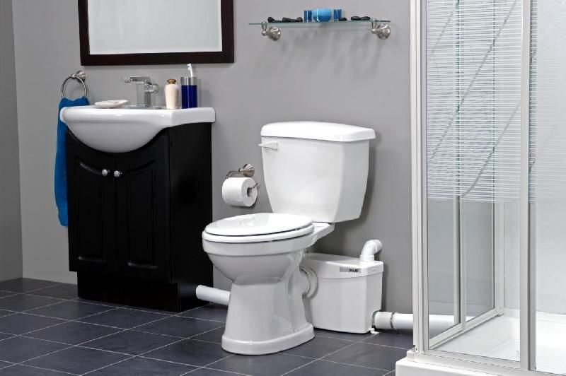 A bathroom with a toilet , sink and shower.