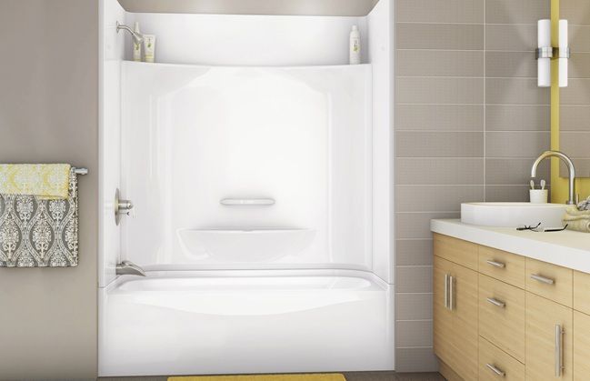 A bathroom with a bathtub , sink and mirror.