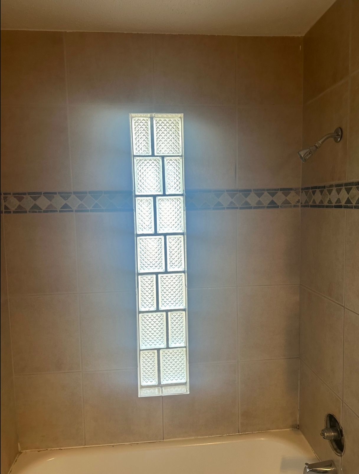 A bathroom with a toilet , tub and mirror.
