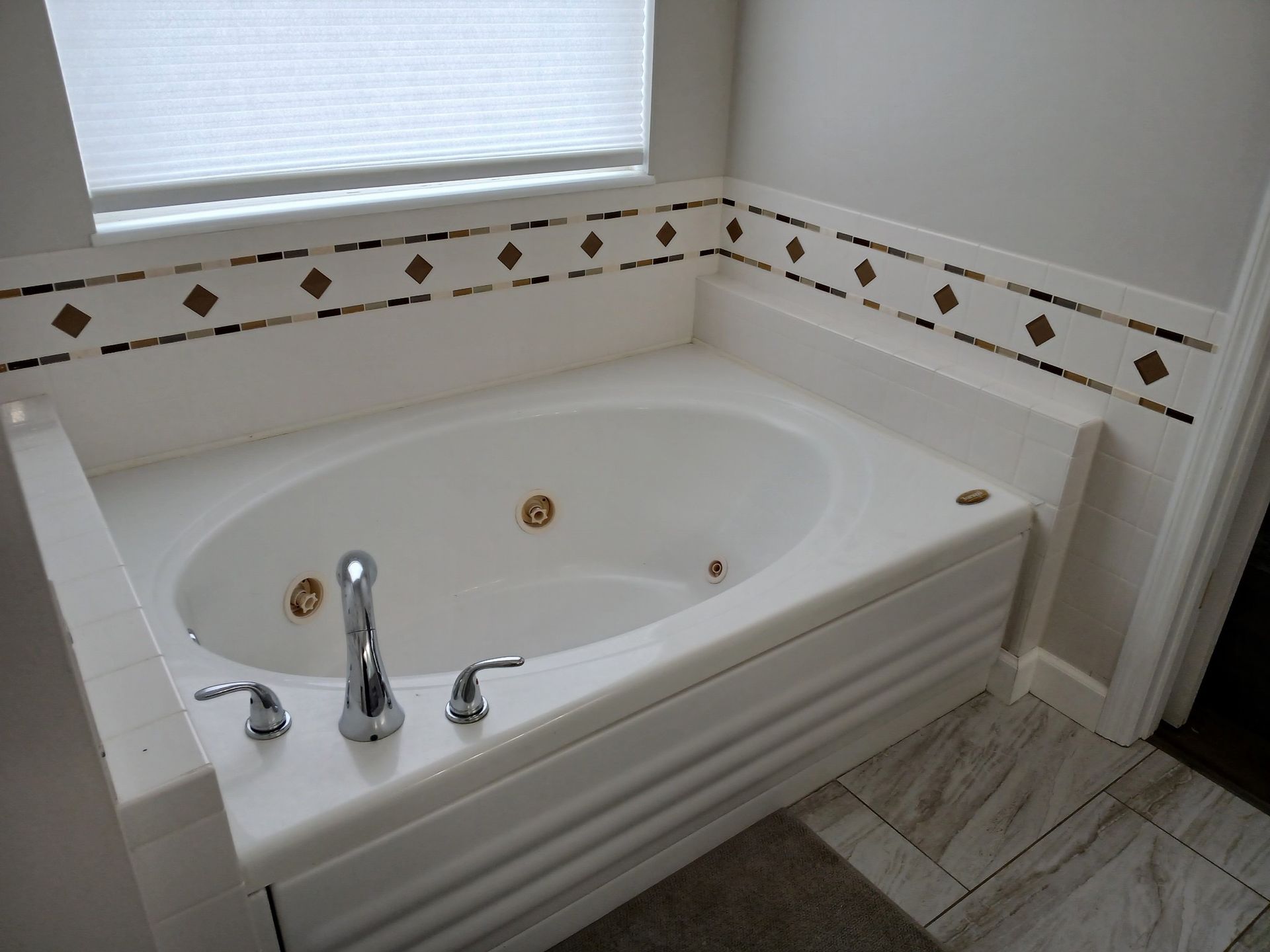 A jacuzzi tub in a bathroom next to a window