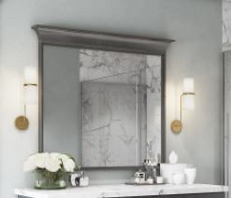 A bathroom with a large mirror and a vanity.