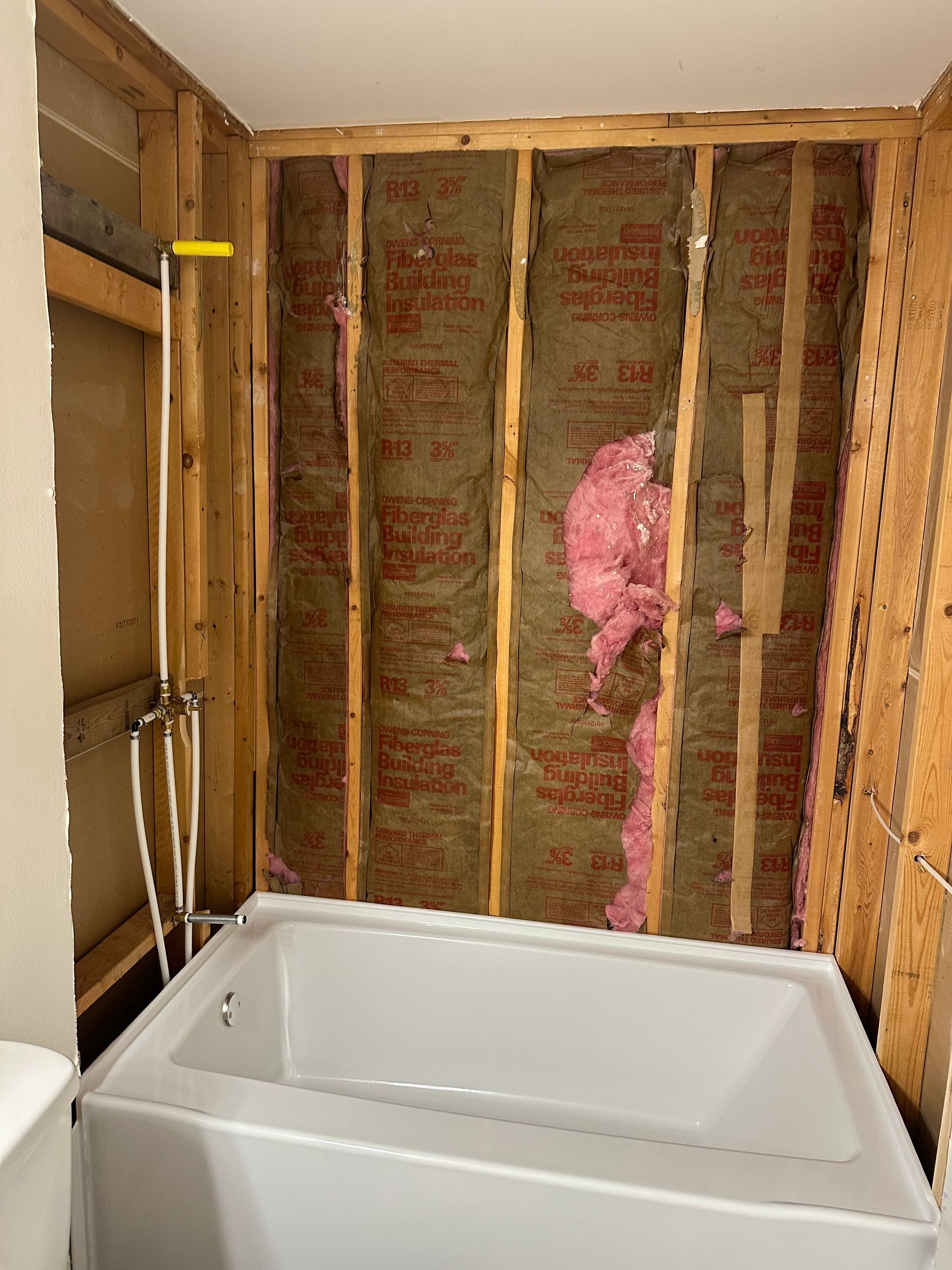 A bathtub is sitting in a bathroom under construction.