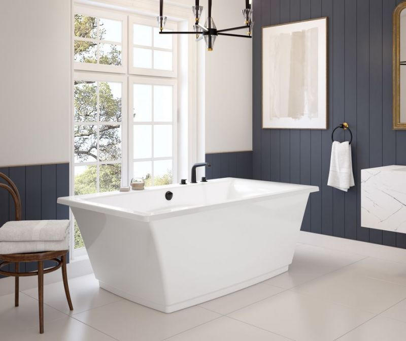 A bathroom with a white bathtub and a chair.