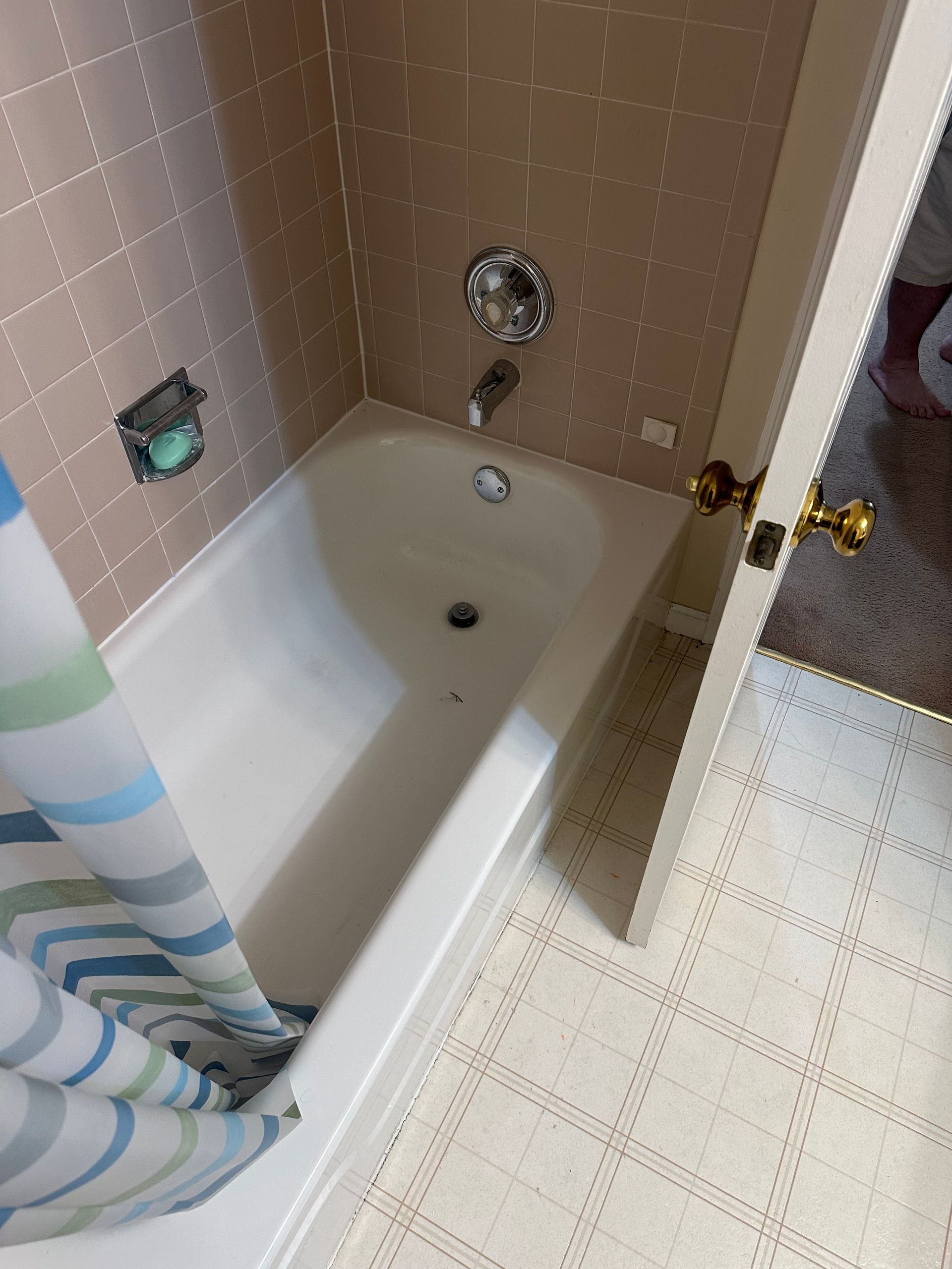 A bathtub in a bathroom with a shower curtain on it.