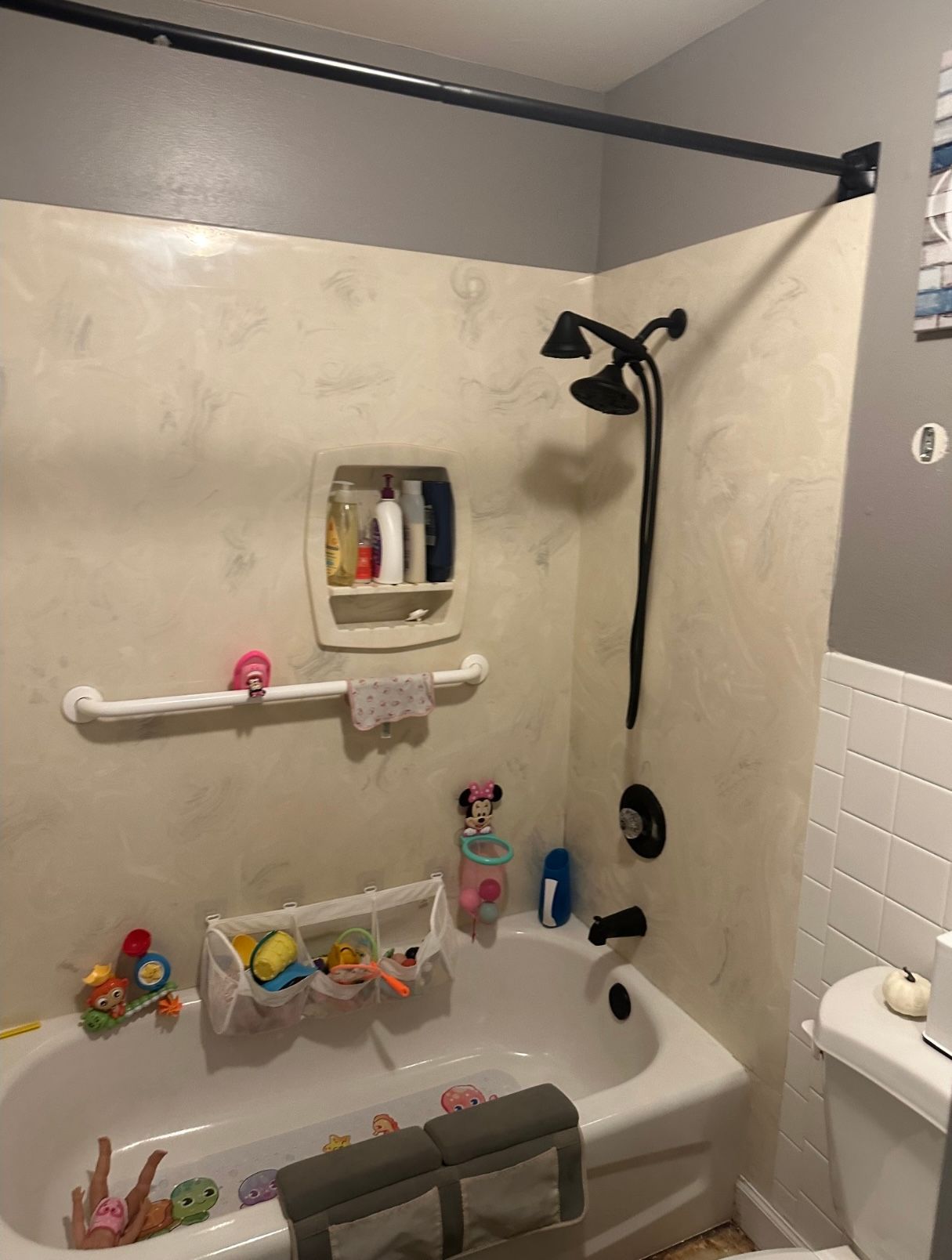 A bathroom with a toilet , tub and mirror.
