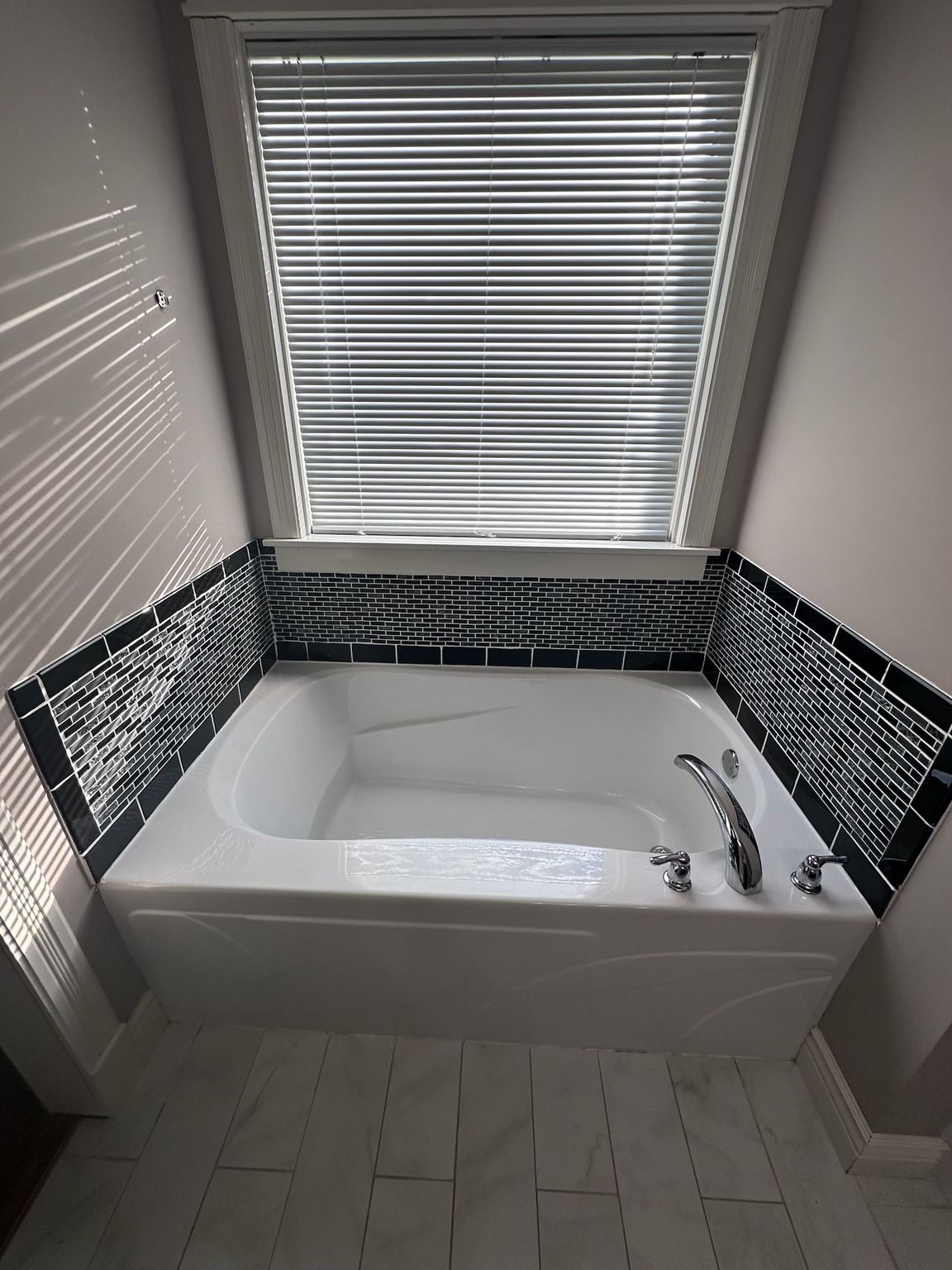 A bathroom with a shower , toilet , sink and mirror.