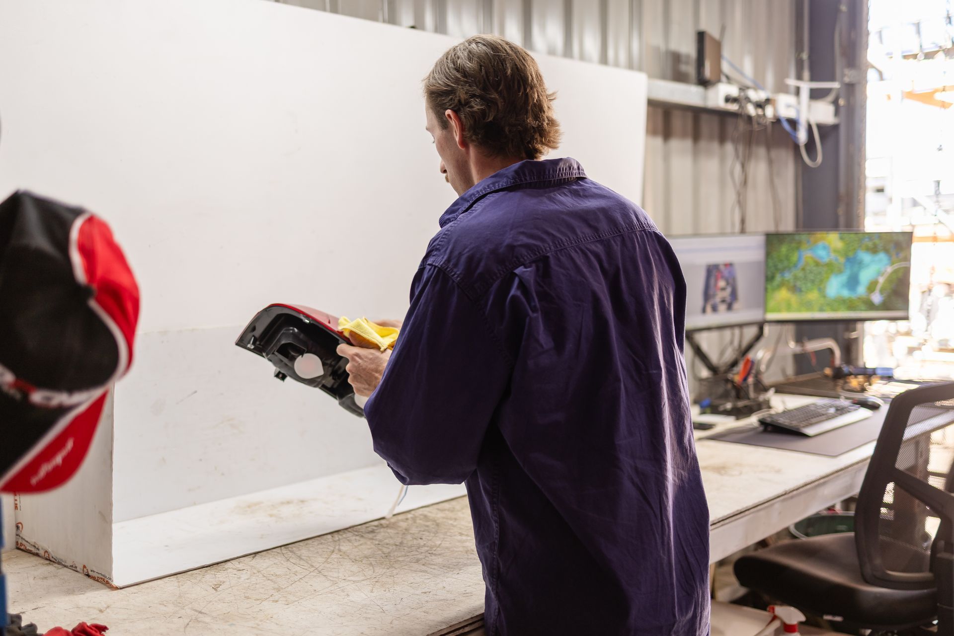 A man in blue overalls checking parts— Scott's 4WD Parts Plus In Dubbo, NSW