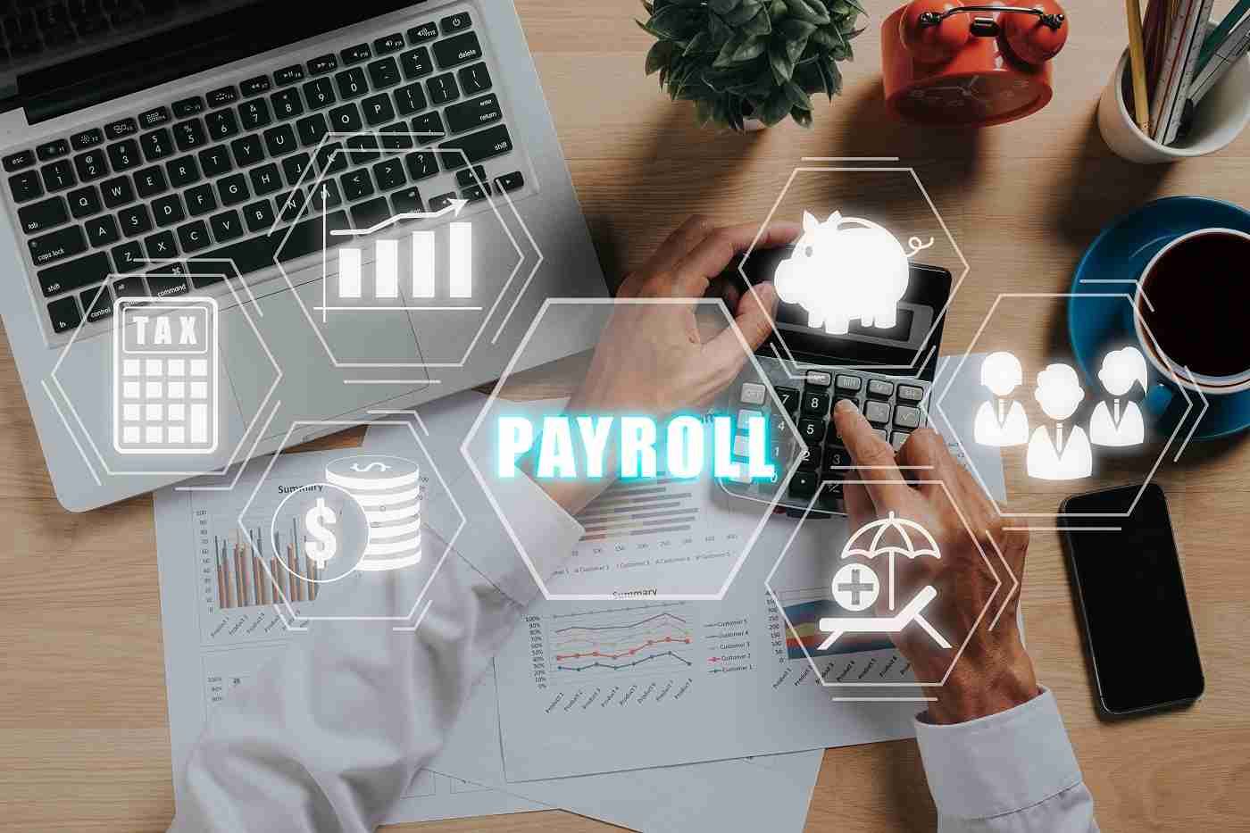 Payroll documents and digital icons over a desk with laptop, calculator, coffee, and hands working