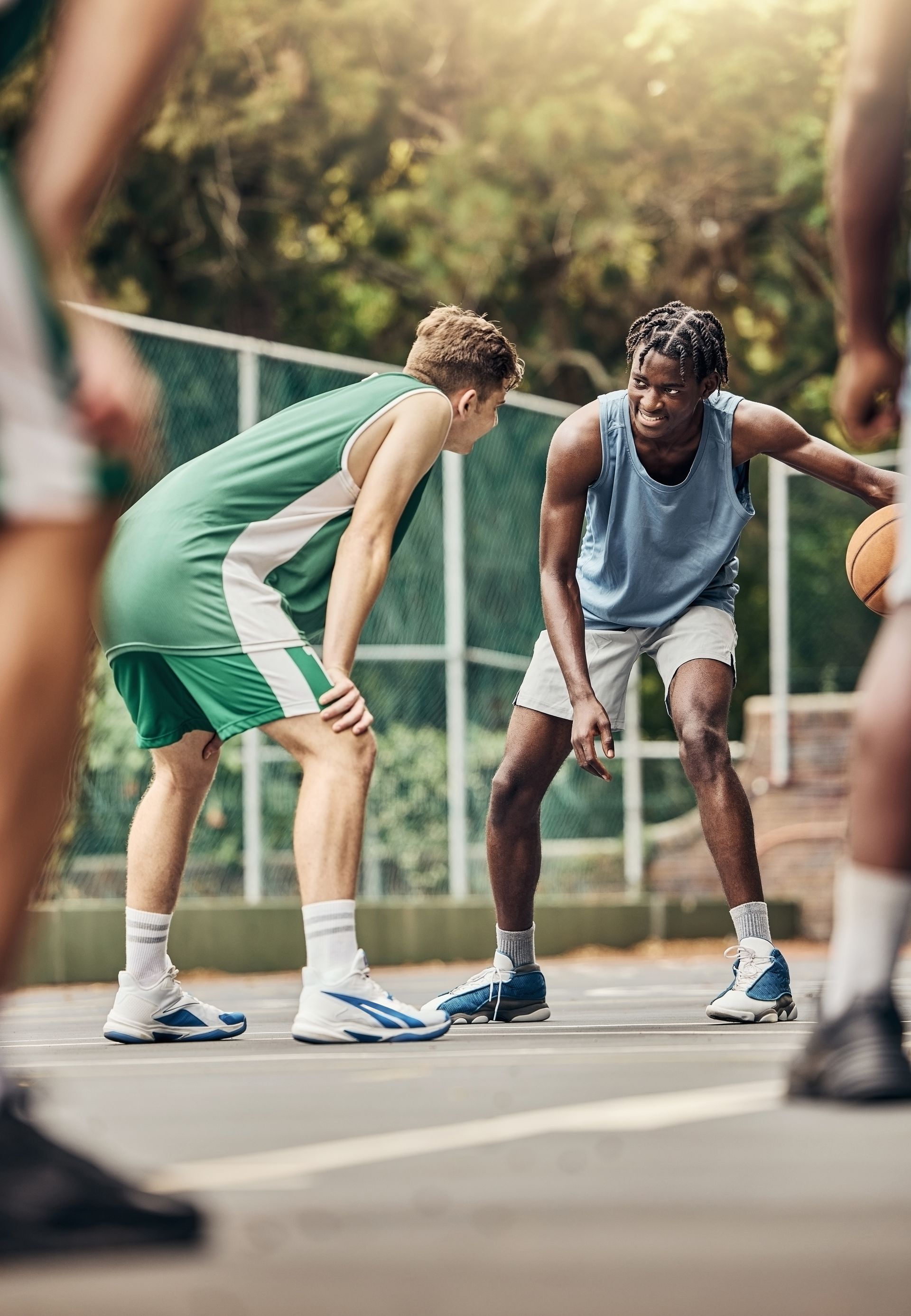 A group of young men are playing basketball on a court.