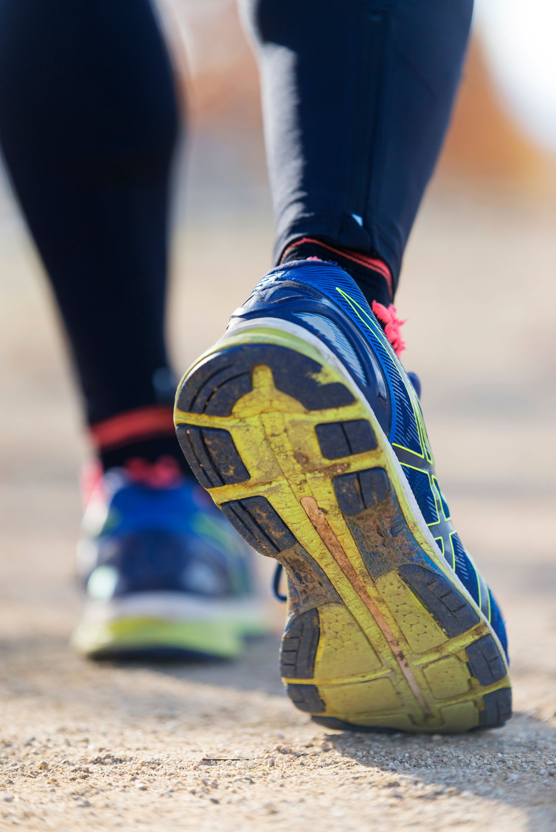 A close up of a person 's feet wearing running shoes.