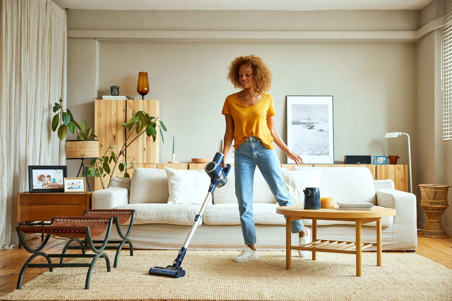 Woman cleaning carpet with vacuum cleaner at home.