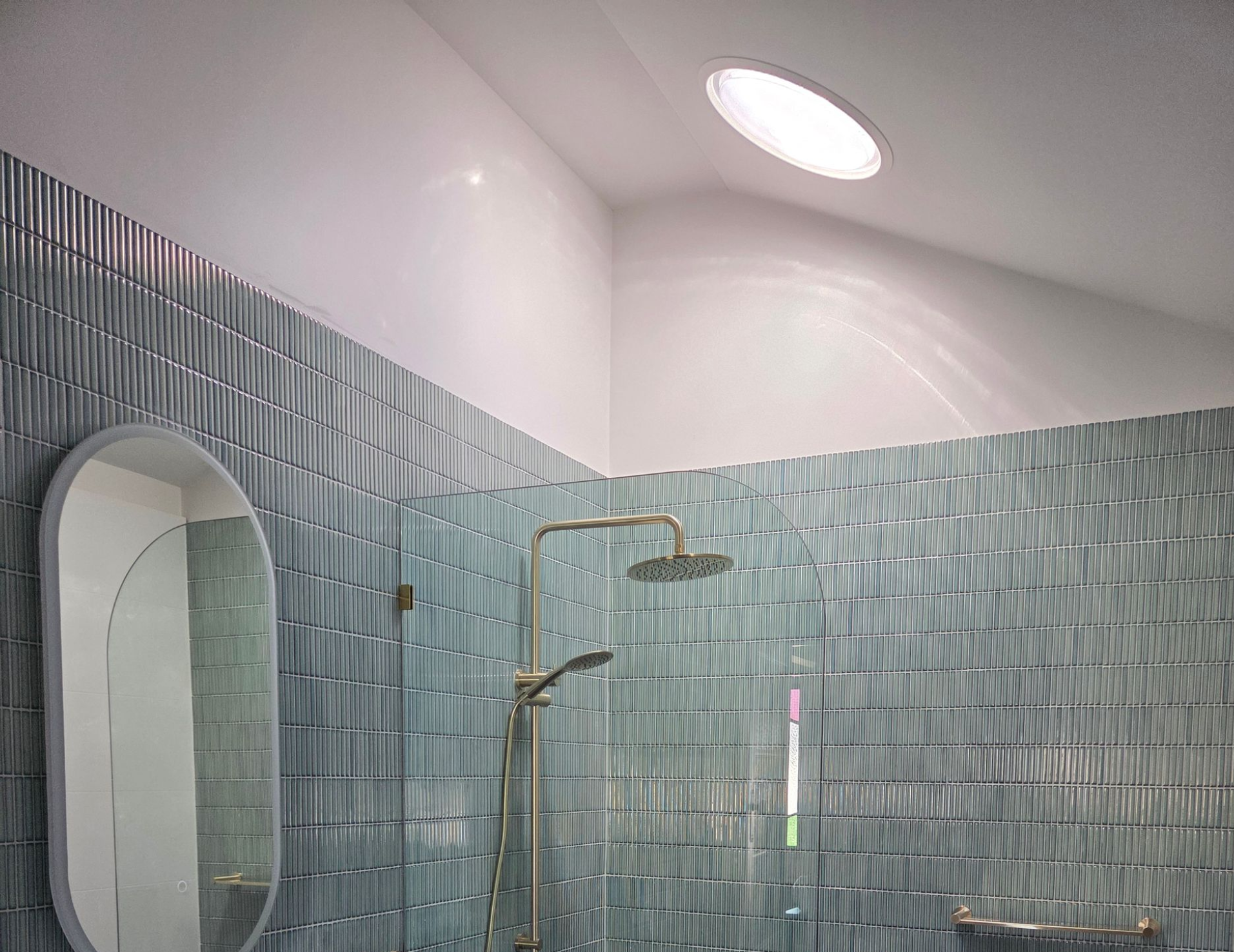Modern Bathroom With Blue Textured Tile, Oval Mirror, Floating Vanity — Beyond Skylights in Byron Bay, NSW