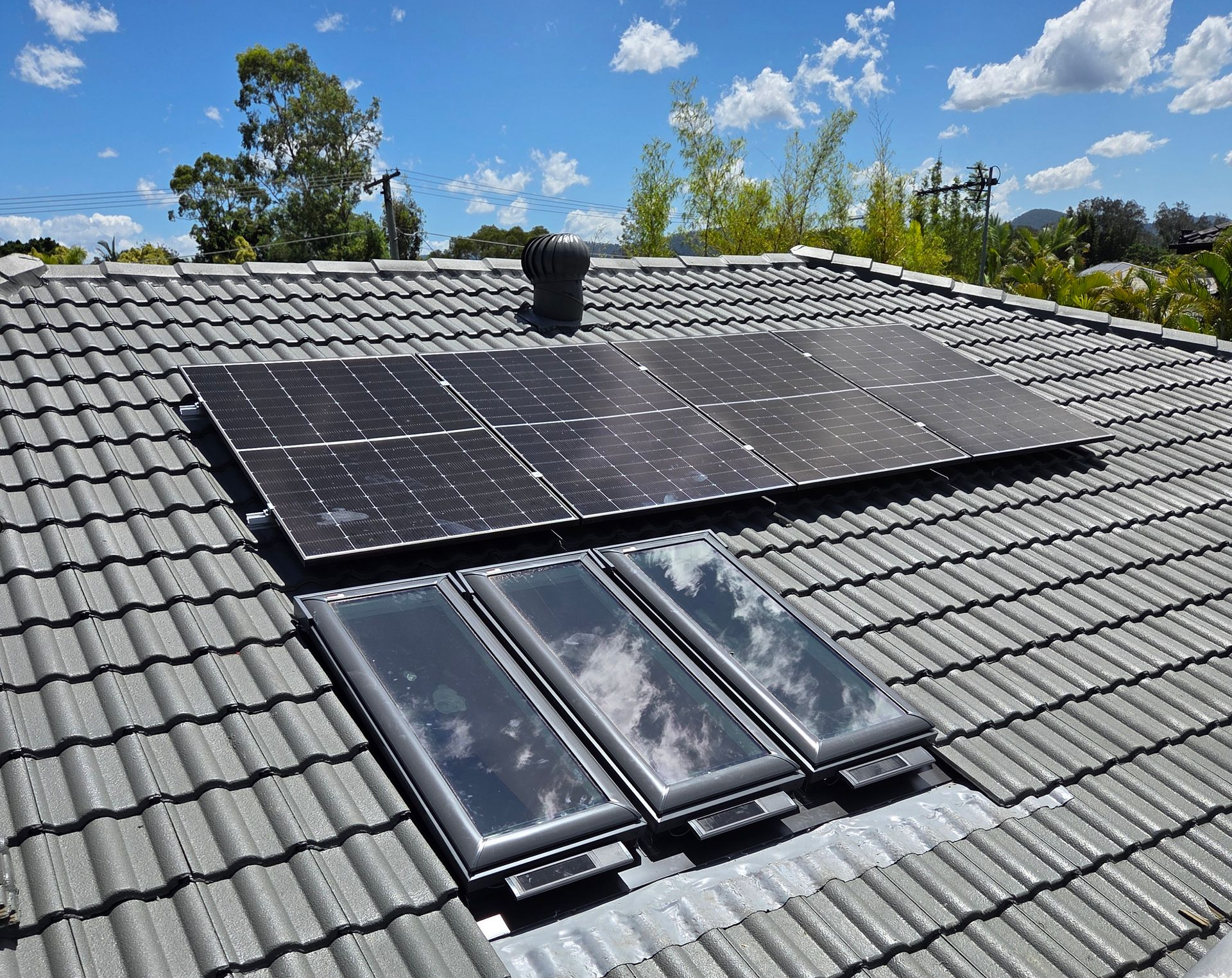 Solar Panels Installed on a Gray Tiled Roof Under a Blue Sky — Beyond Skylights in Byron Bay, NSW