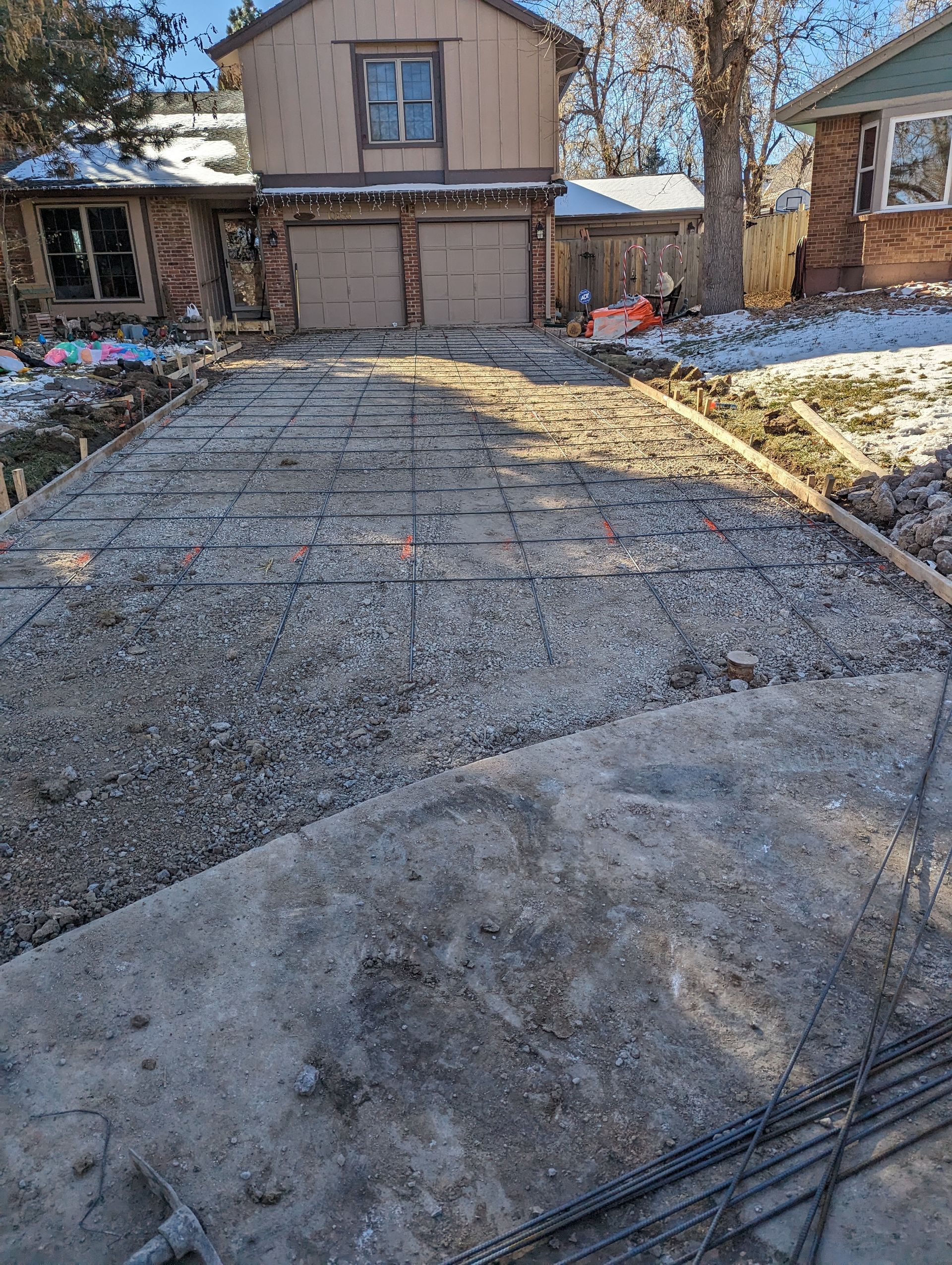 A concrete driveway is being built in front of a house.