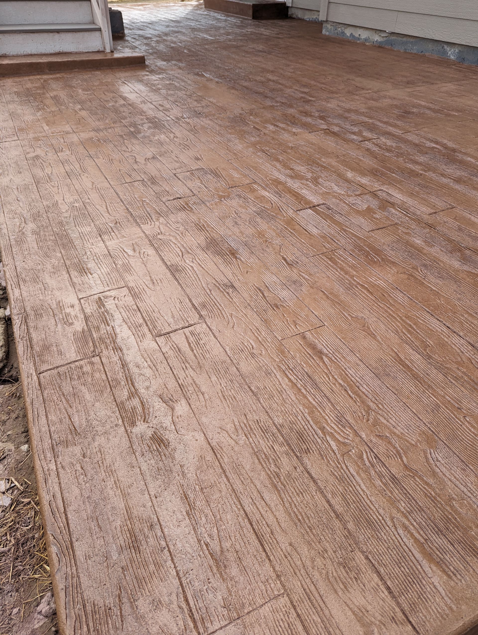 A concrete walkway that looks like wood is being built.