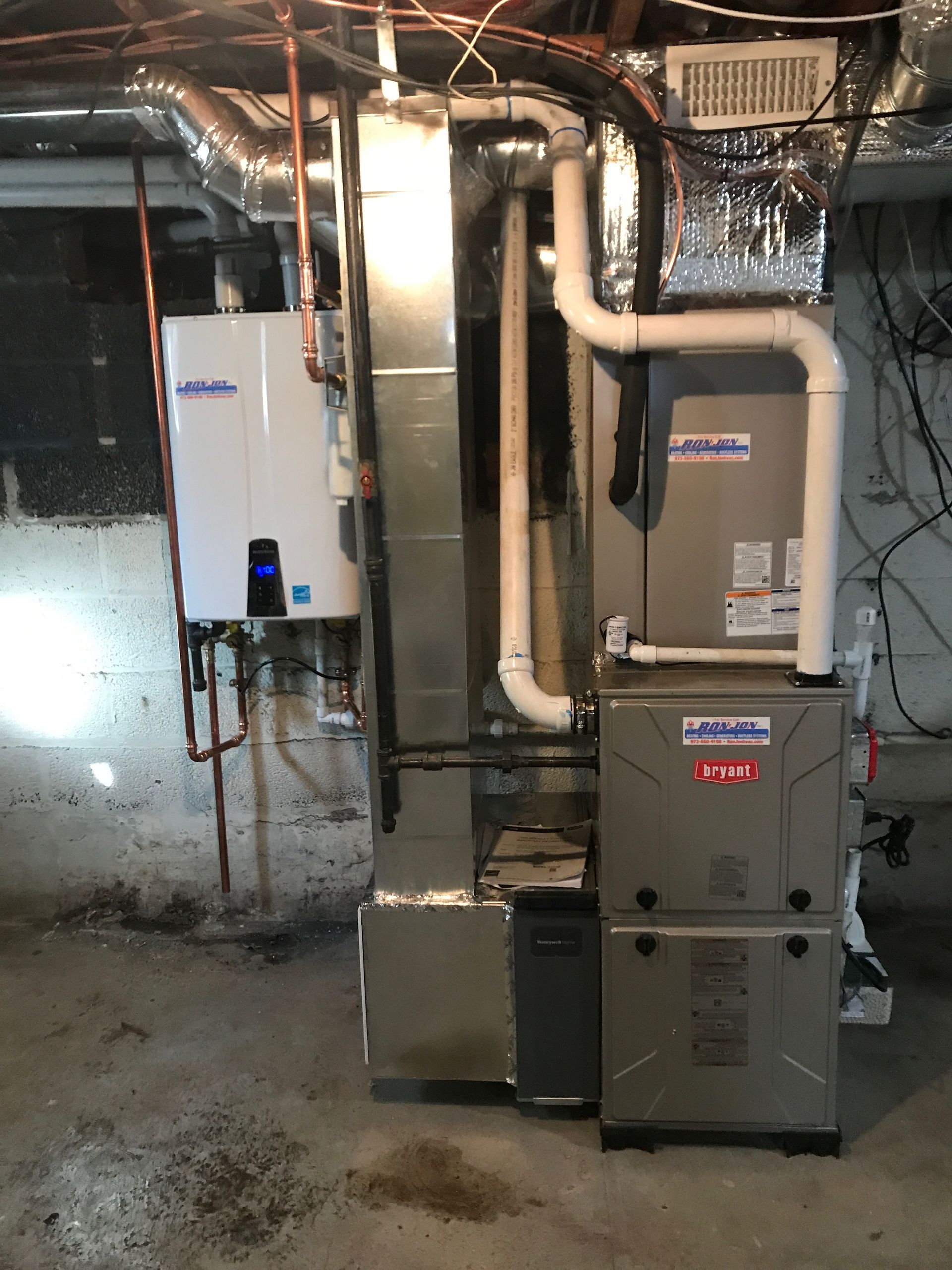 Basement utility room with HVAC furnace, water heater, exposed ducts, and pipes against concrete walls