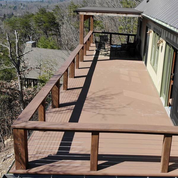Wooden deck attached to a house with a mountainous landscape in the background.