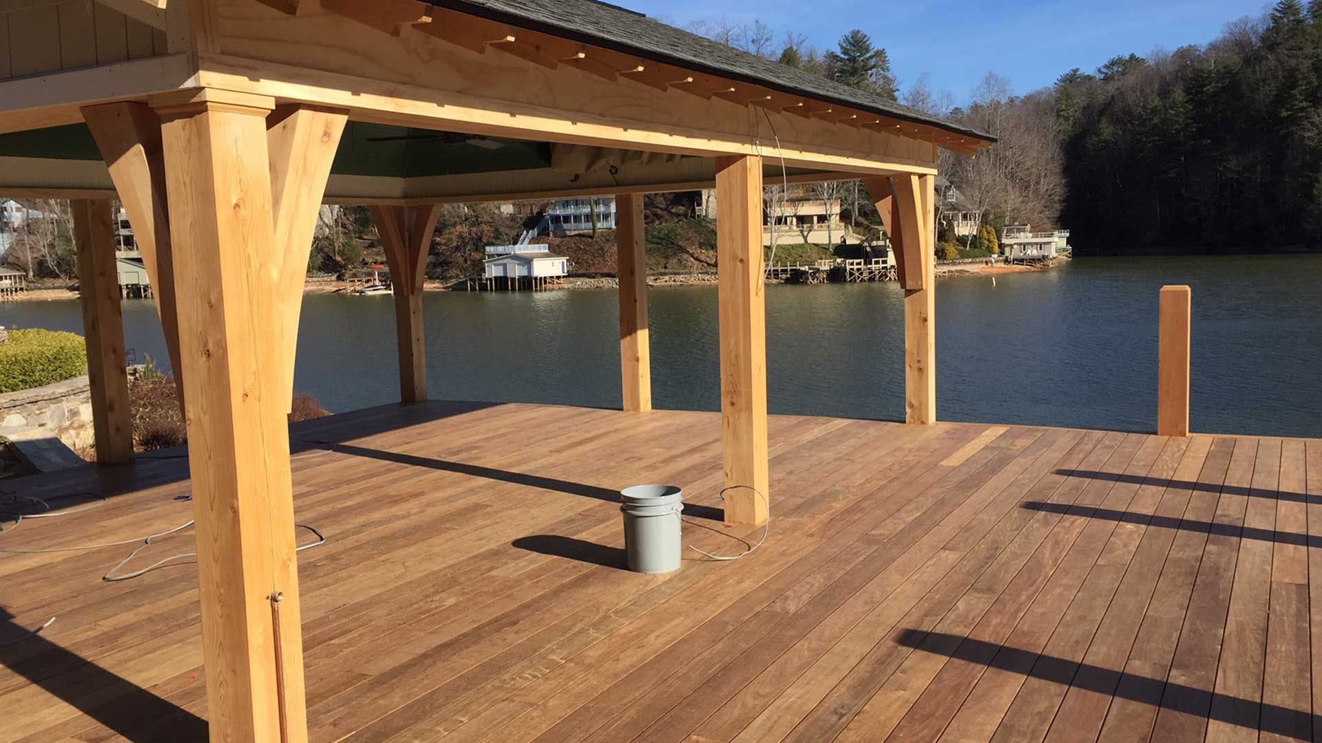 Wooden dock with a covered area extending over calm water.