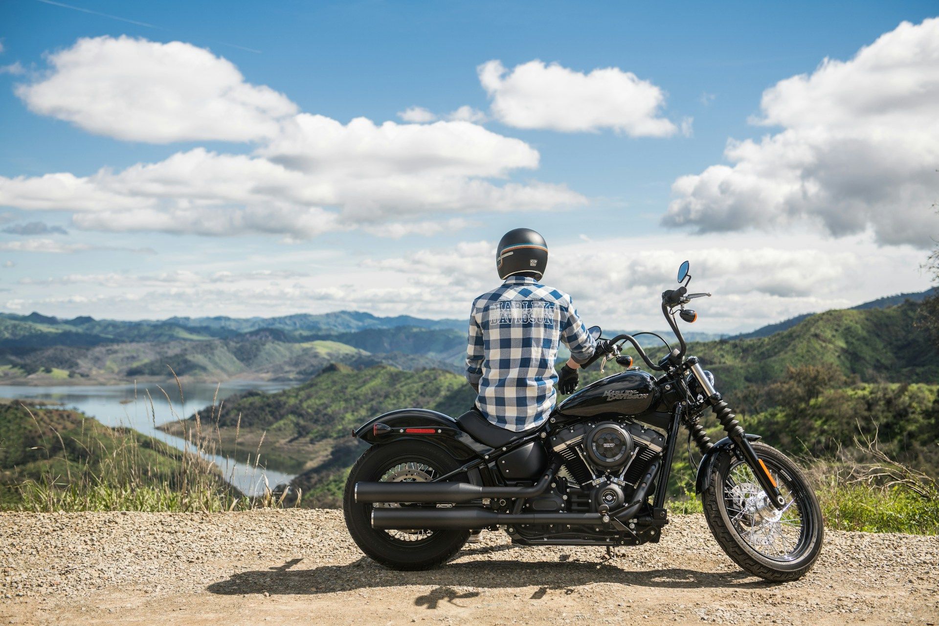 Motorcyclist riding on a country road with blue sky