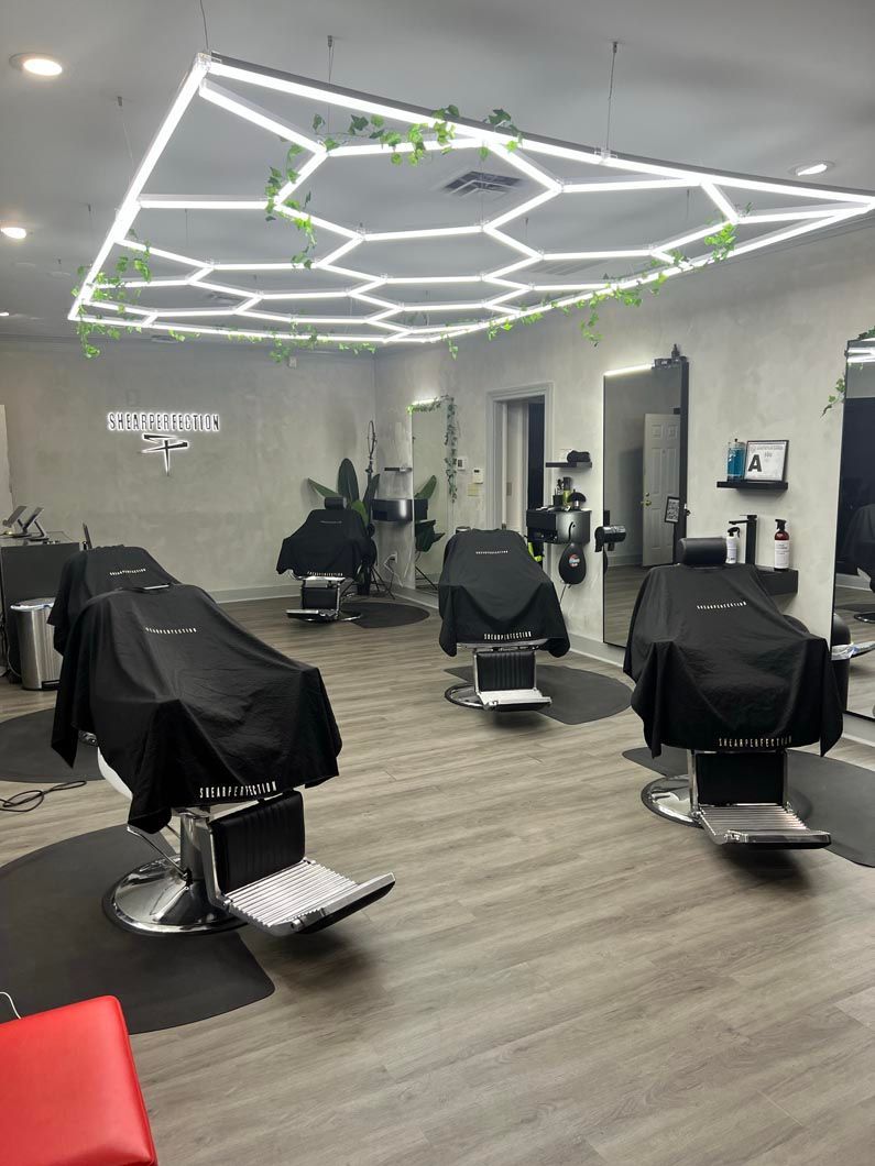 Barbershop interior with chairs covered, hexagon-lit ceiling, and mirrors.